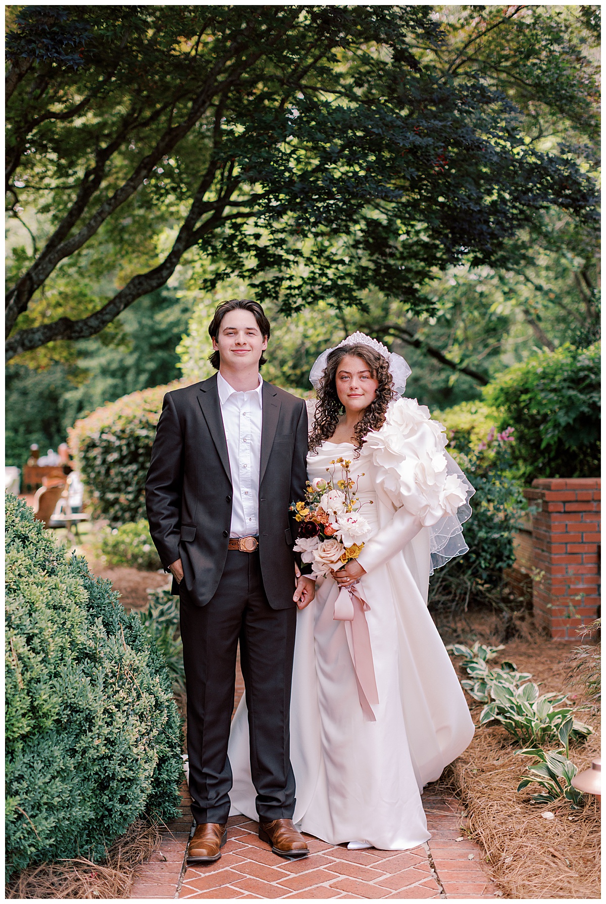 Bride and groom portrait in garden with wildflower bouquet