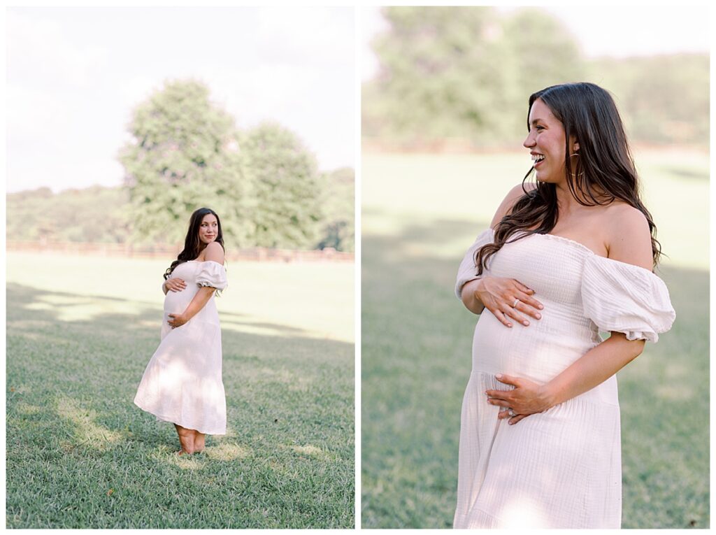 Elizabeth in pale maternity gown, standing in open field at sunset, holding baby bump
