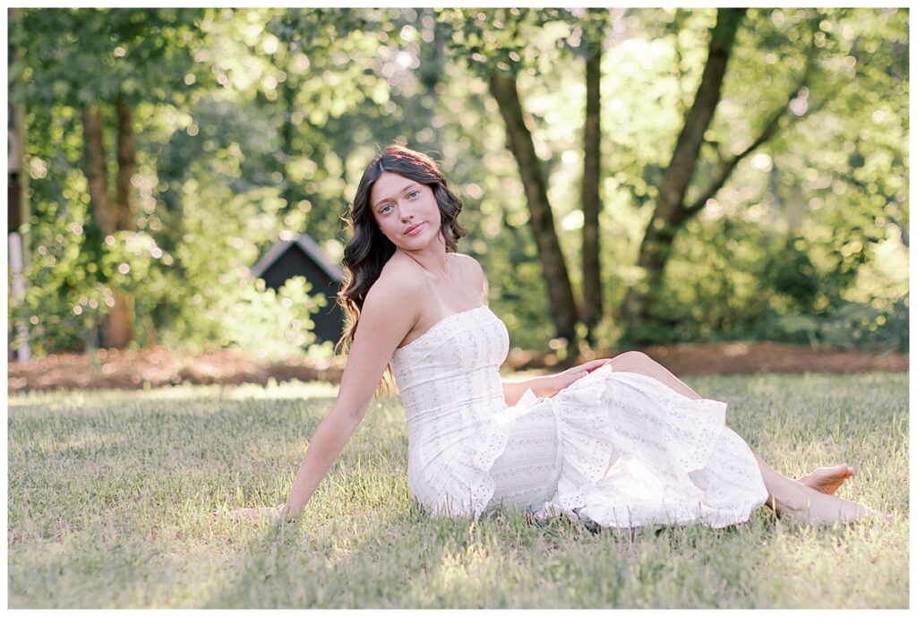 Close senior portrait of Kynslie seated in the garden flowers at The McGarity House.