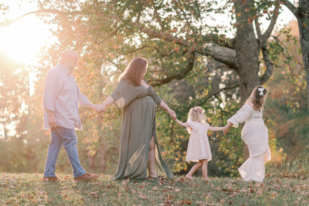 Family embracing together in warm evening light during fall family photos in Dallas, Georgia.