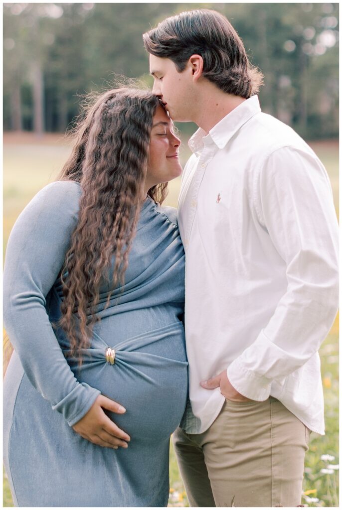 Expecting mother in blue maternity dress photographed among wildflowers at Fairfield Plantation.