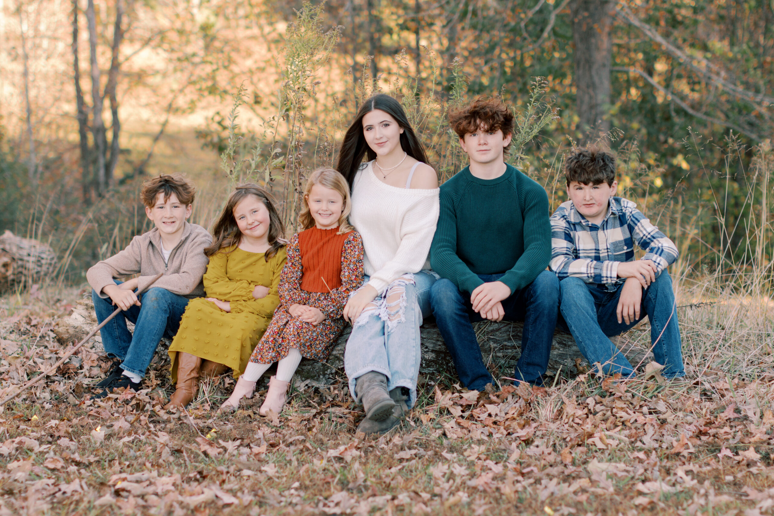 Parents and six children standing together beneath an autumn oak tree during a sunset family session at White Oak Park in Dallas, Georgia.