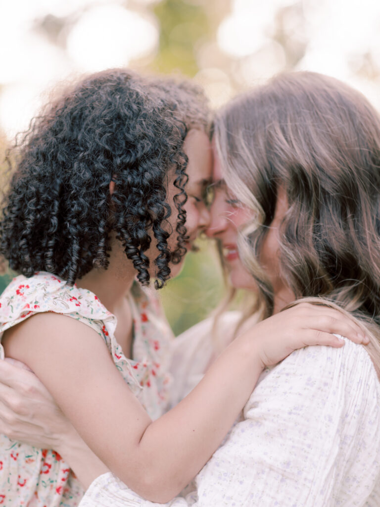 Mother and her daughter pressing their foreheads together during an outdoor family session.